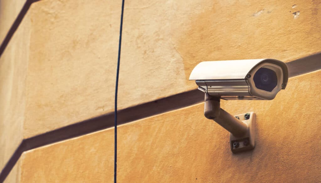 A surveillance camera installed on an outdoor wall of a business