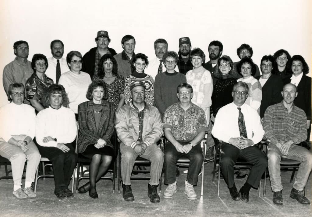 Black & white group photo of 26 NDTC employees in 1994, arranged in three rows.