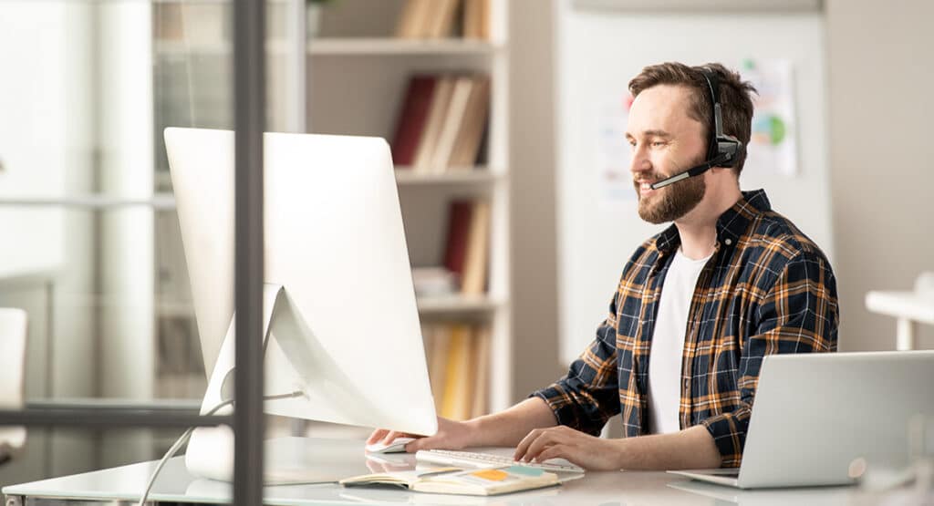 Worker typing at support desk.