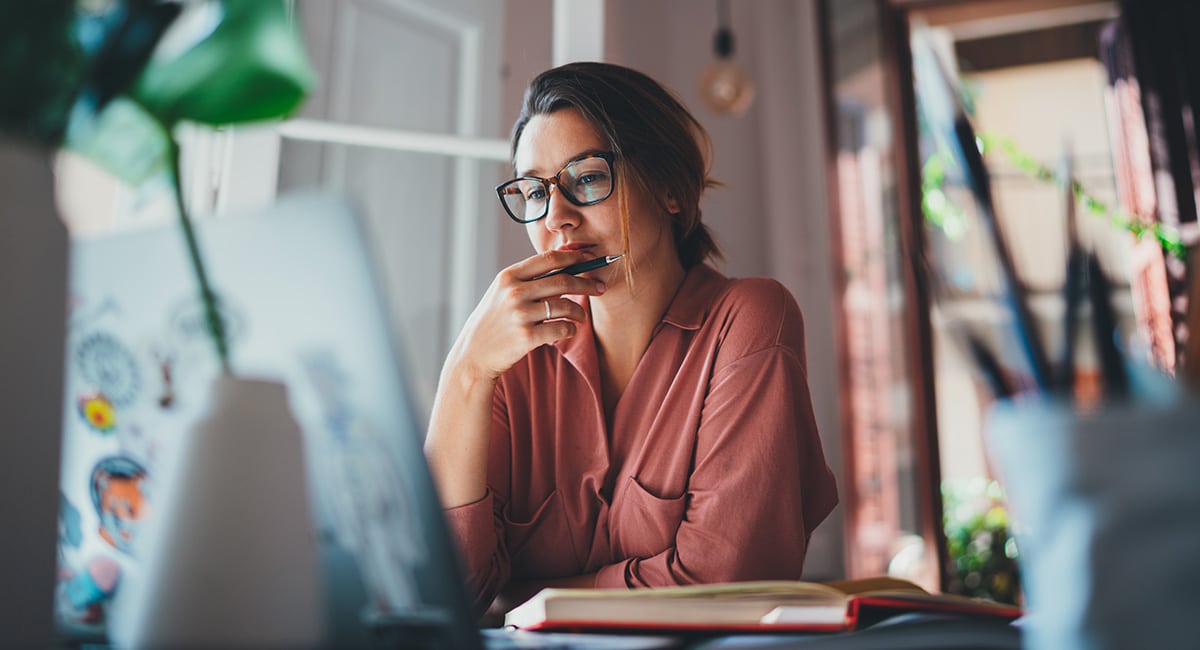 Woman using laptop at desk.