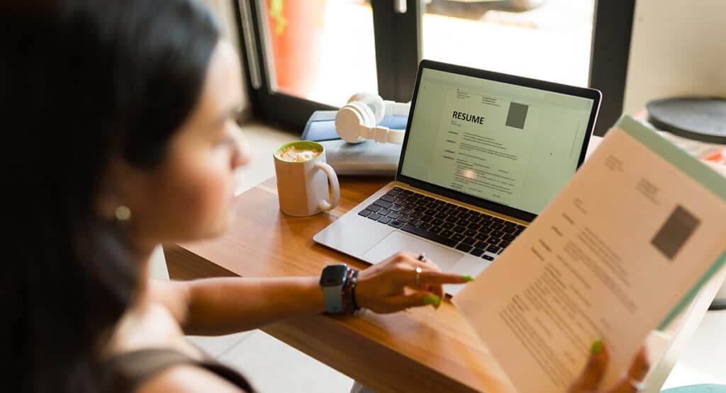 Person updating resume on laptop.